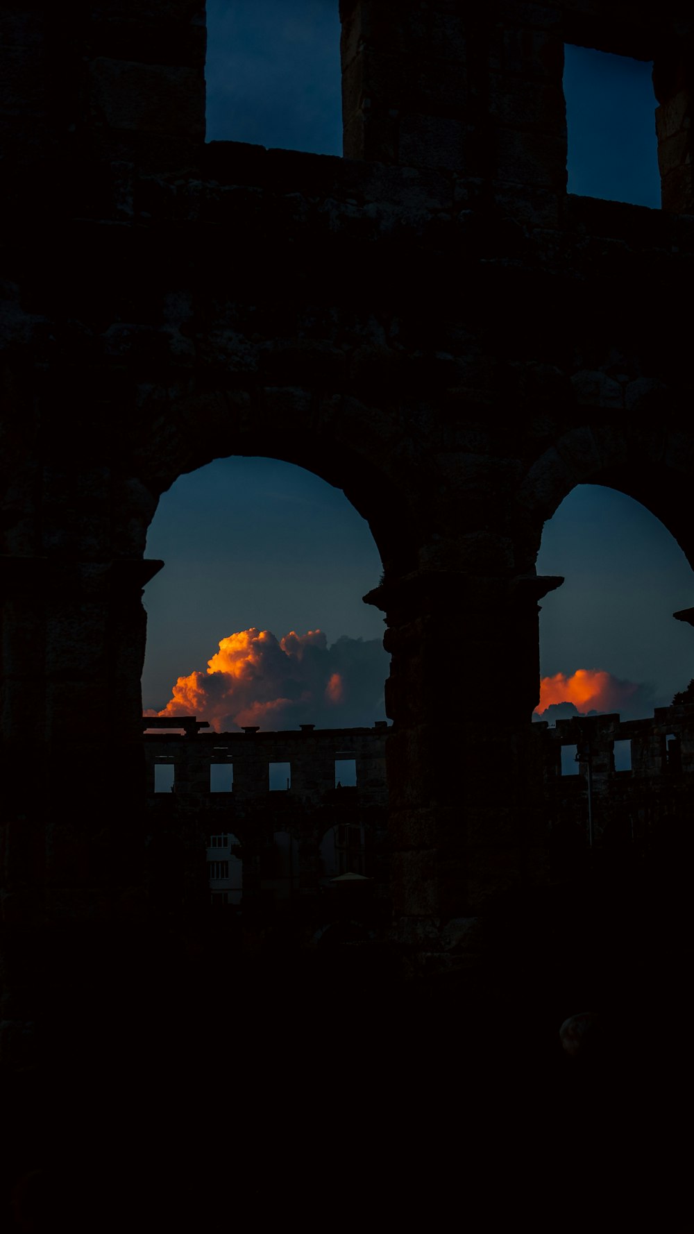 a view of a sunset through an arch in a building
