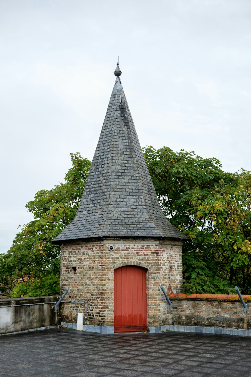 a small brick building with a red door