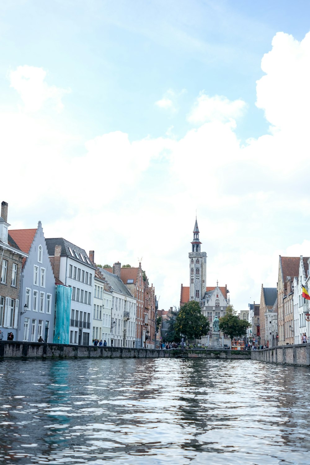 a body of water with buildings and a clock tower in the background