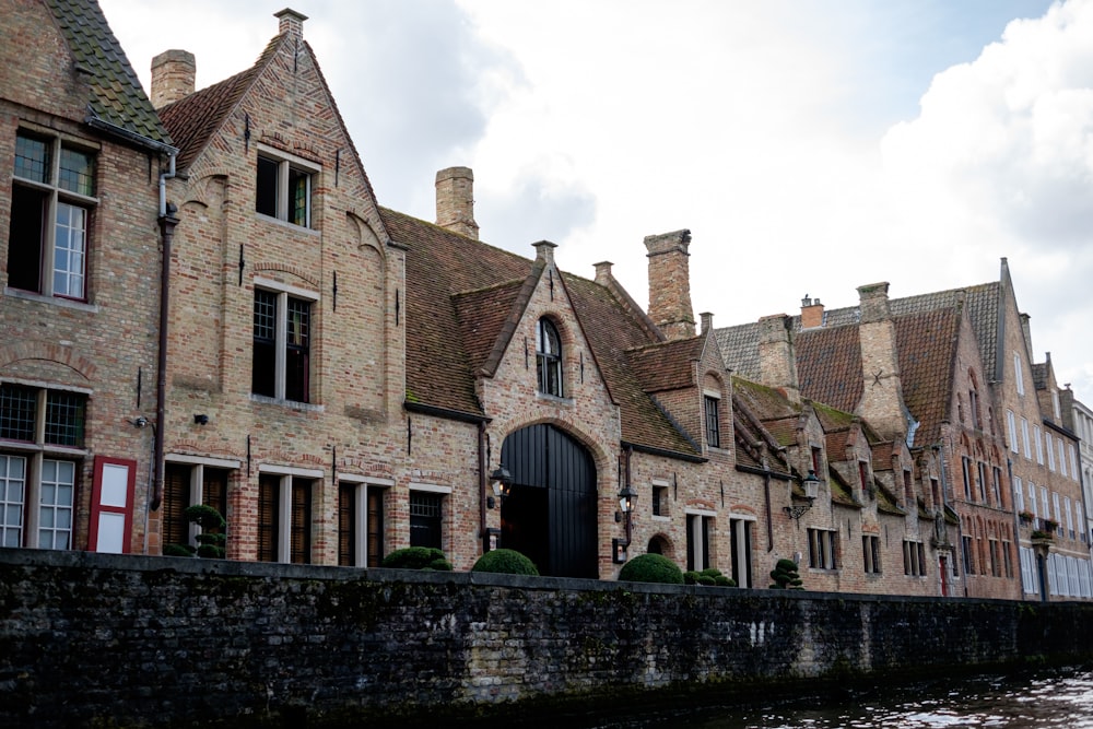 a row of brick buildings next to a body of water