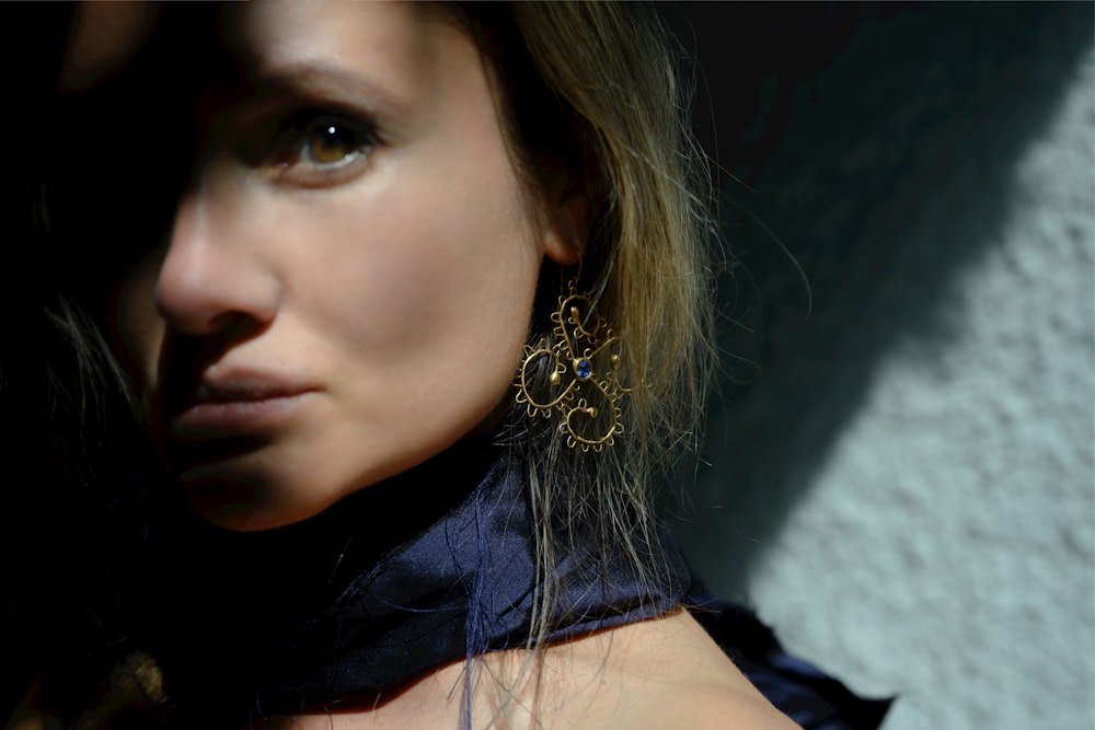 a close up of a person wearing a necklace and earrings