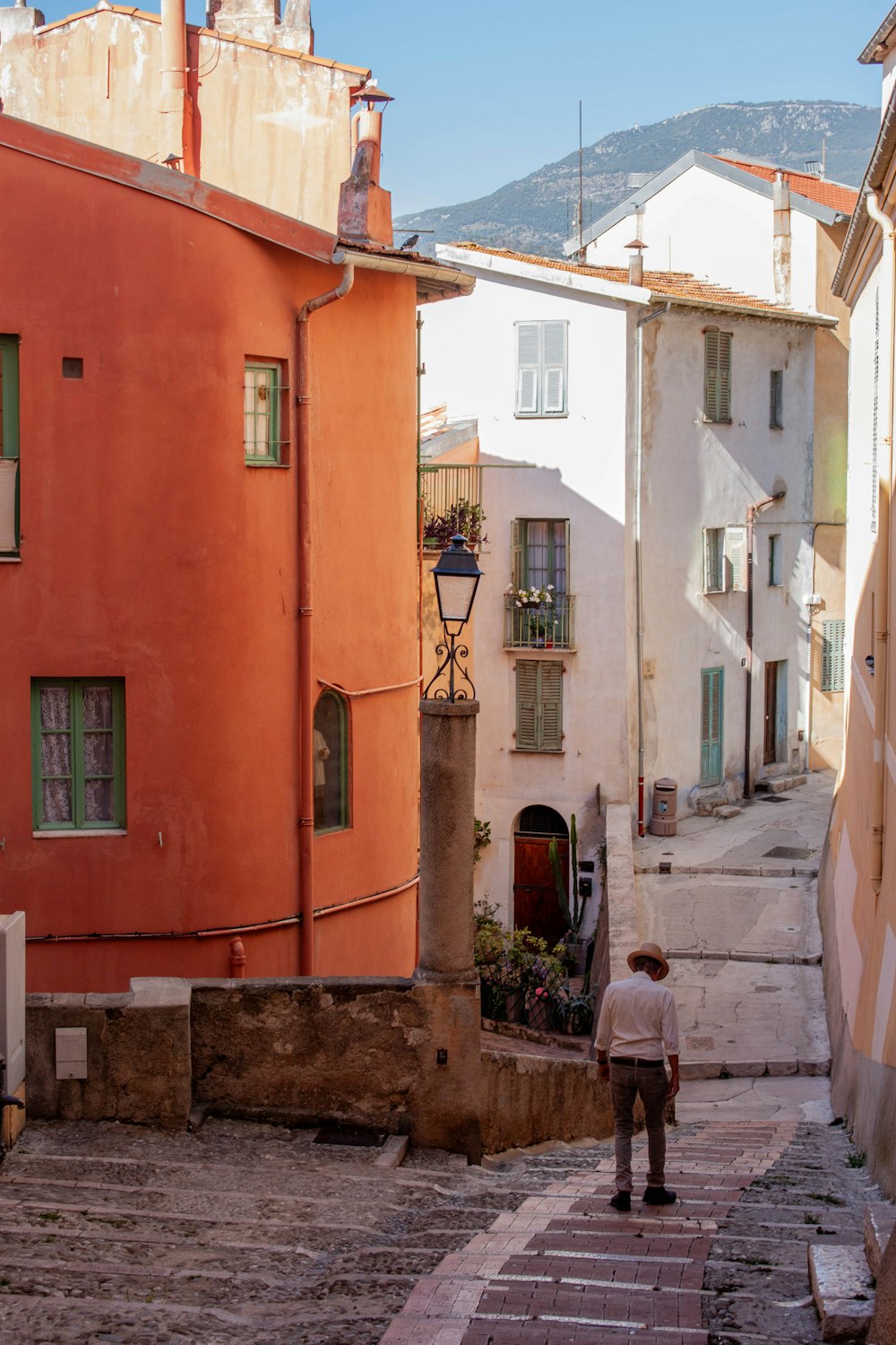 a man is walking down a cobblestone street