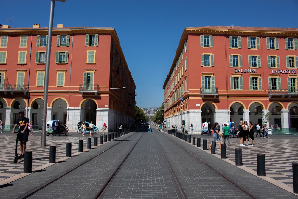 Un gruppo di persone che camminano lungo una strada accanto a edifici alti