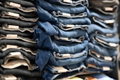Flat lay of carefully graded jackets and jeans arranged neatly with tags showing quality grades A+, A, and B.