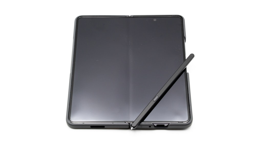 a tablet with a pen sitting on top of it