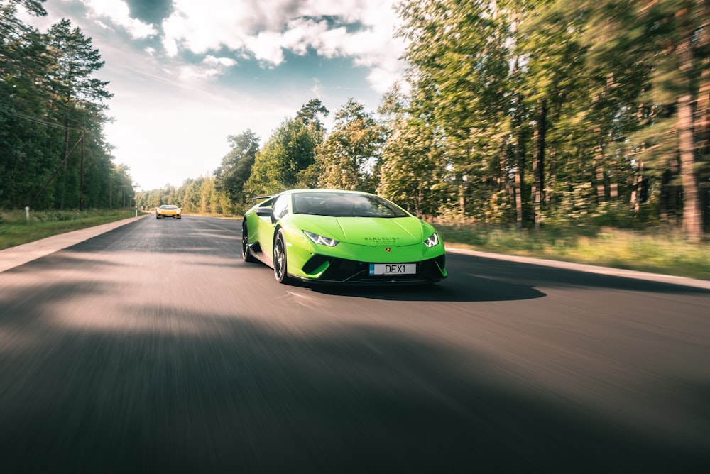 a green sports car driving down the road