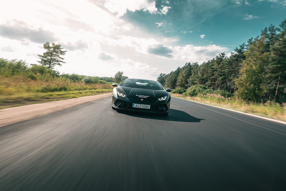 a black sports car driving down the road