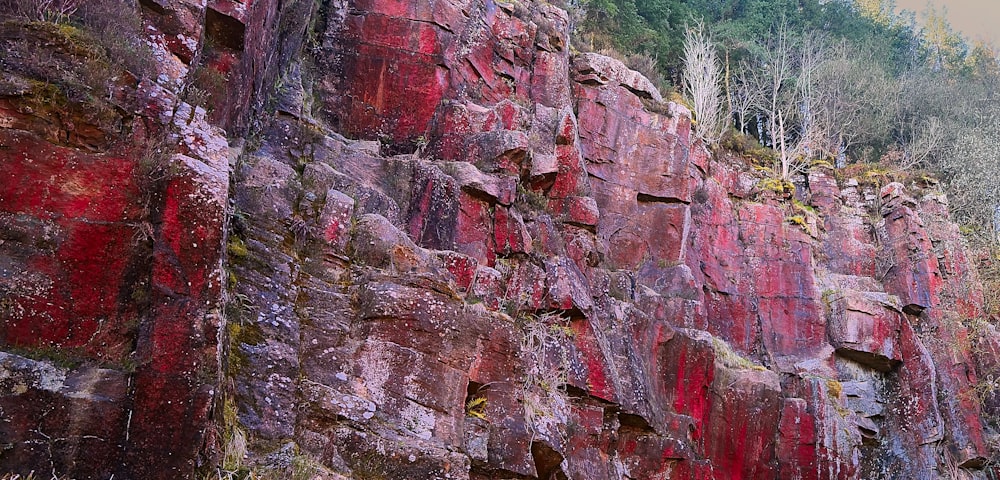 a large rock wall with red paint on it