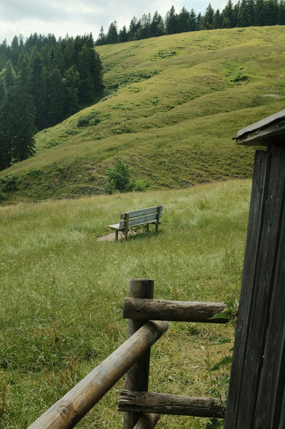 a wooden bench sitting on top of a lush green hillside