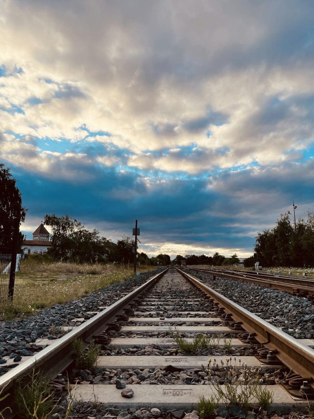 a train track with a cloudy sky in the background