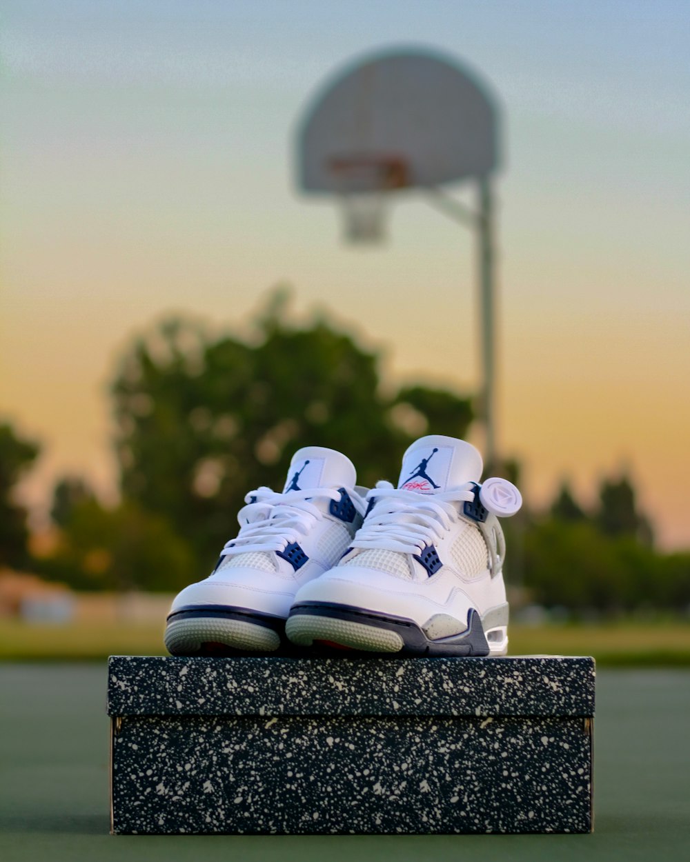 a pair of white shoes sitting on top of a cement block