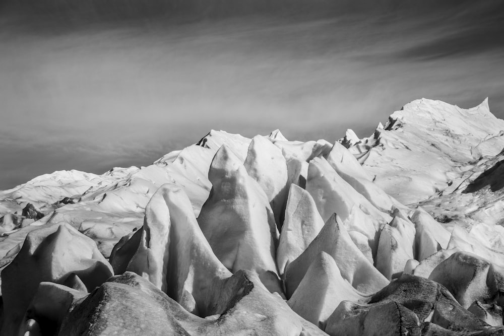 a large mountain covered in snow under a cloudy sky