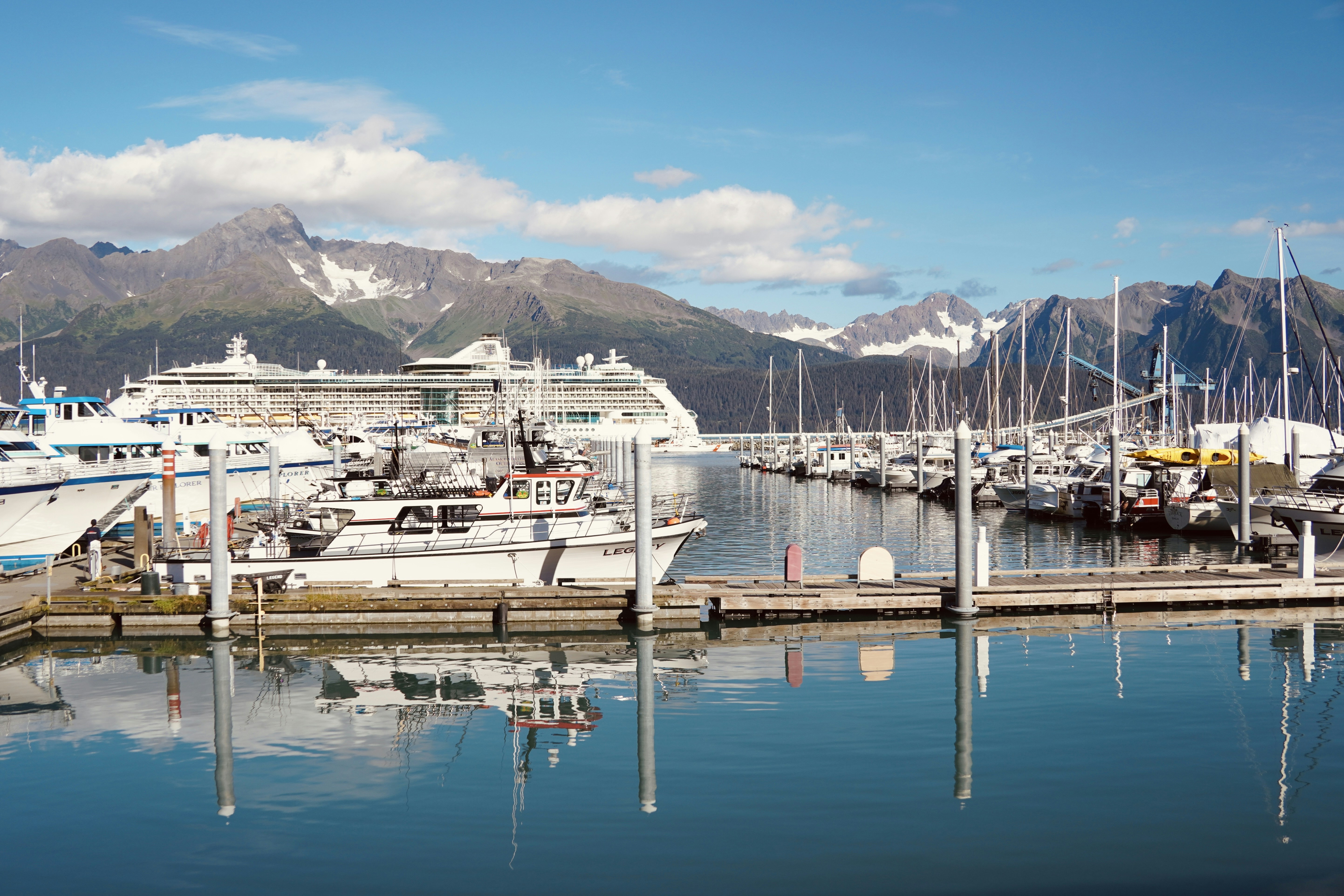 a marina filled with lots of boats and mountains in the background