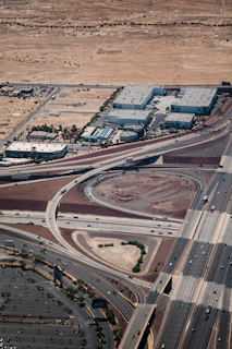 An aerial view of cargo trucks navigating a highway connecting major cities in the Middle East.