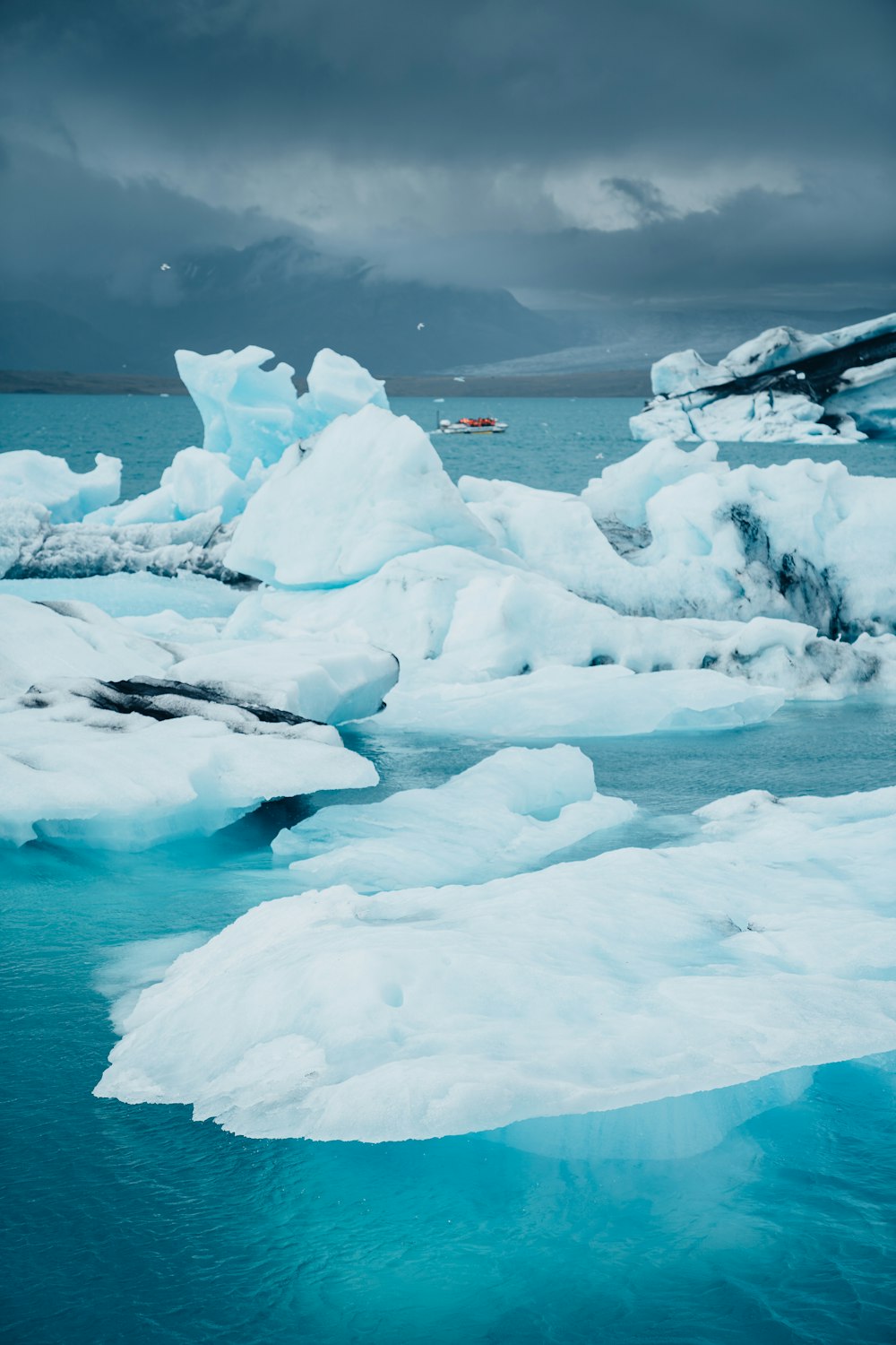 a group of icebergs floating on top of a body of water