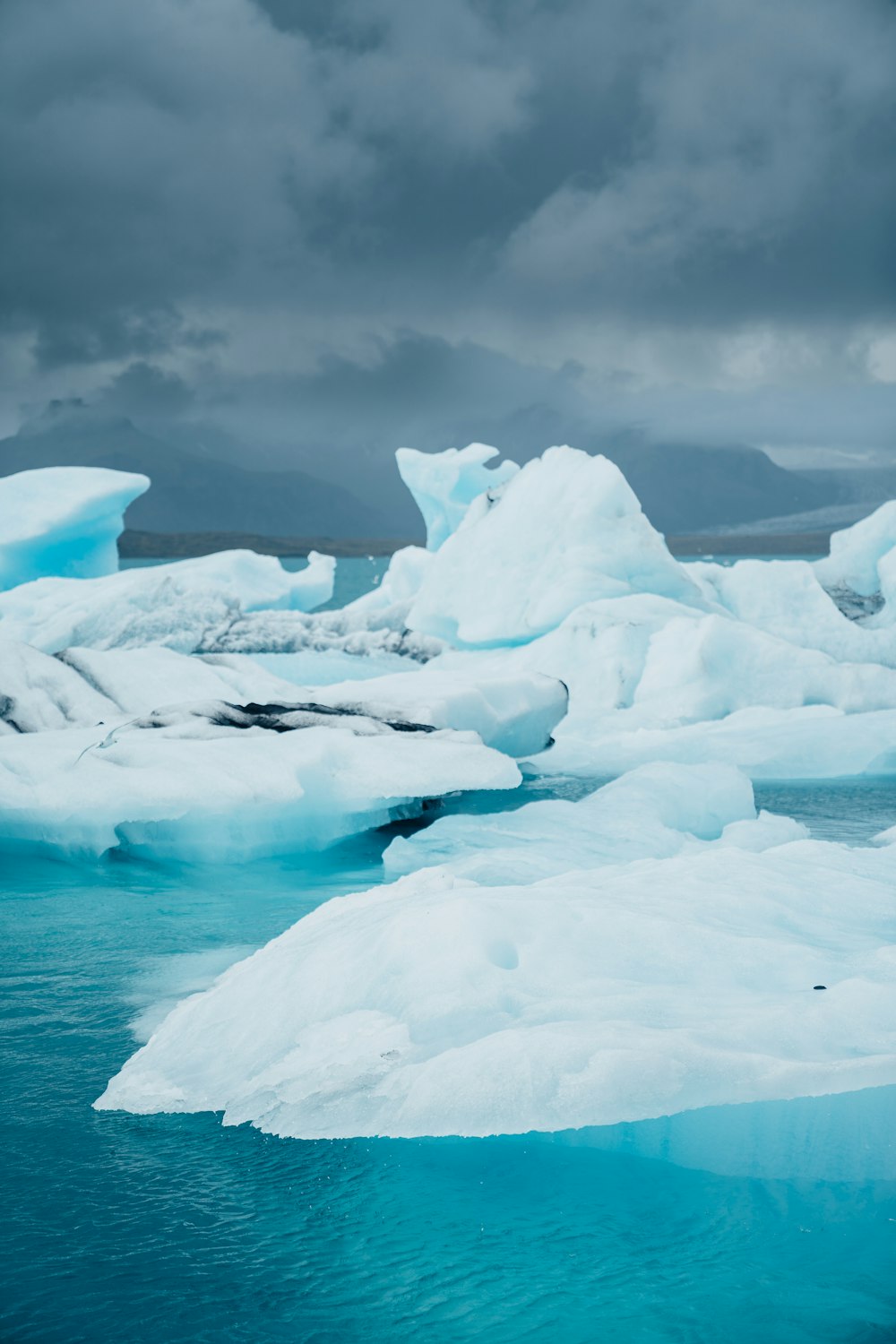 a group of icebergs floating on top of a body of water