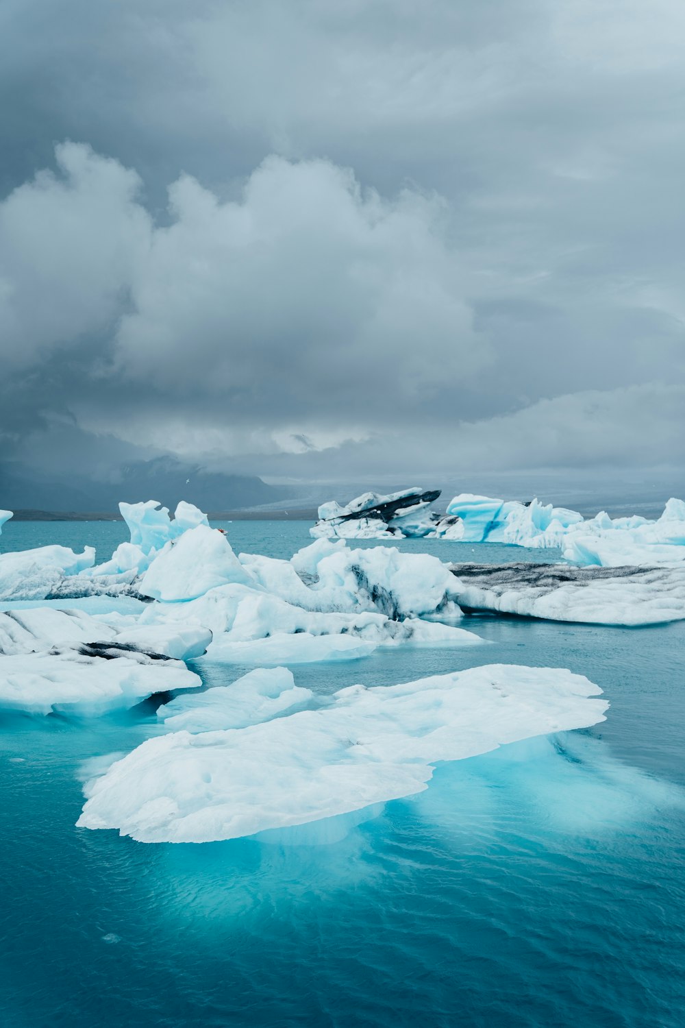 a group of icebergs floating on top of a body of water