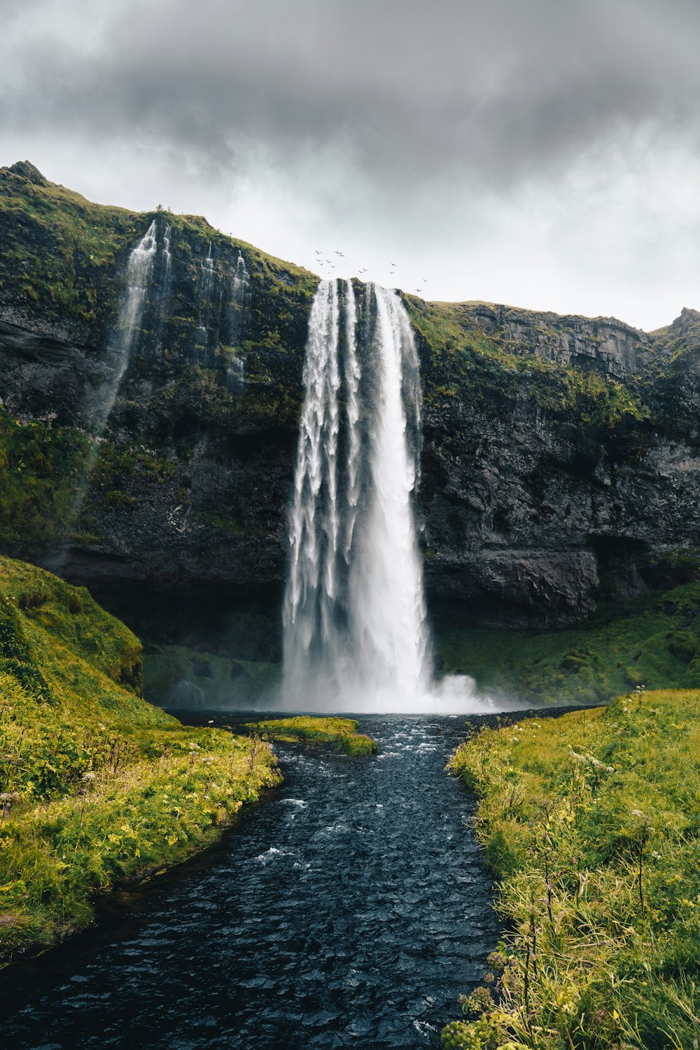 a waterfall with a river running under it