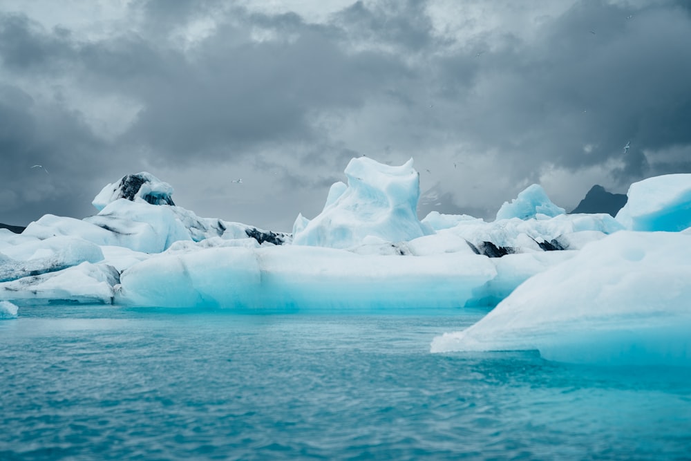 a group of icebergs floating on top of a body of water