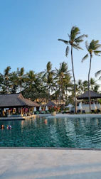 Family enjoying poolside at Residy Retreat Patong under clear blue skies.