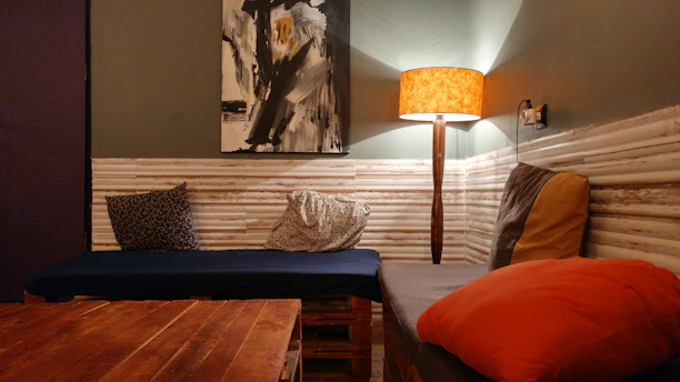 A cozy corner of a home featuring a framed IzzyBizArtistry piece above a wooden side table.