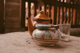 A bright yellow ceramic teapot surrounded by fresh flowers, evoking a warm, slow-living vibe.