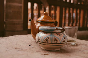 A bright yellow ceramic teapot surrounded by fresh flowers, evoking a warm, slow-living vibe.