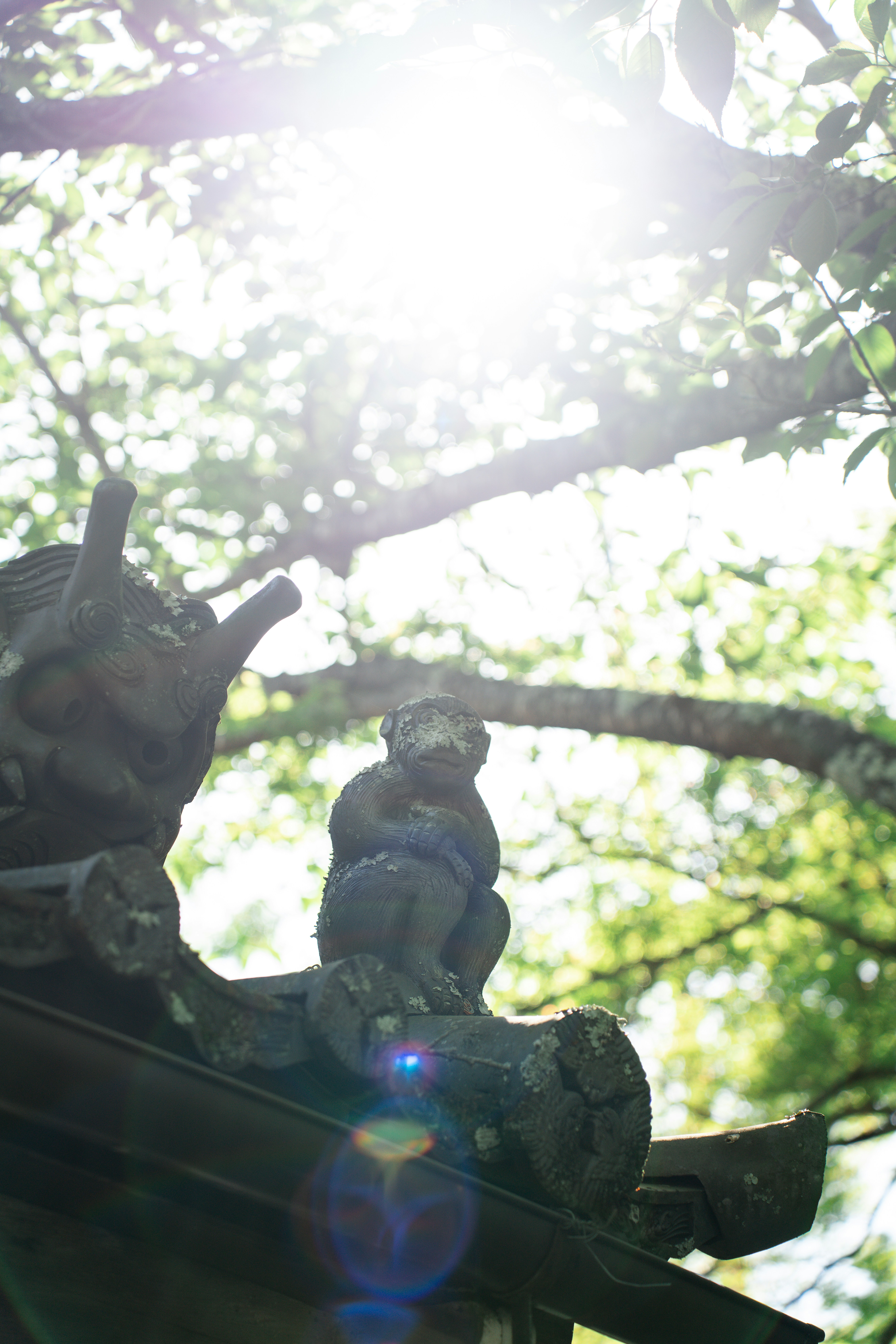 eine Statue eines Elefanten auf einem Dach vor einem Baum