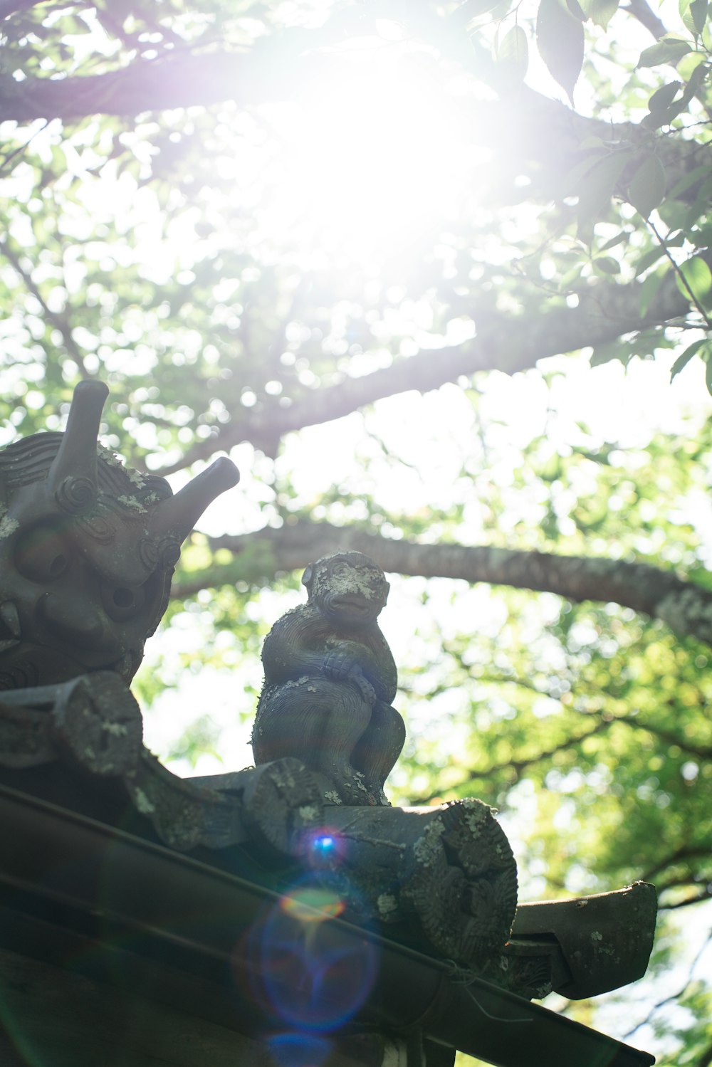 a statue of an elephant on a roof in front of a tree