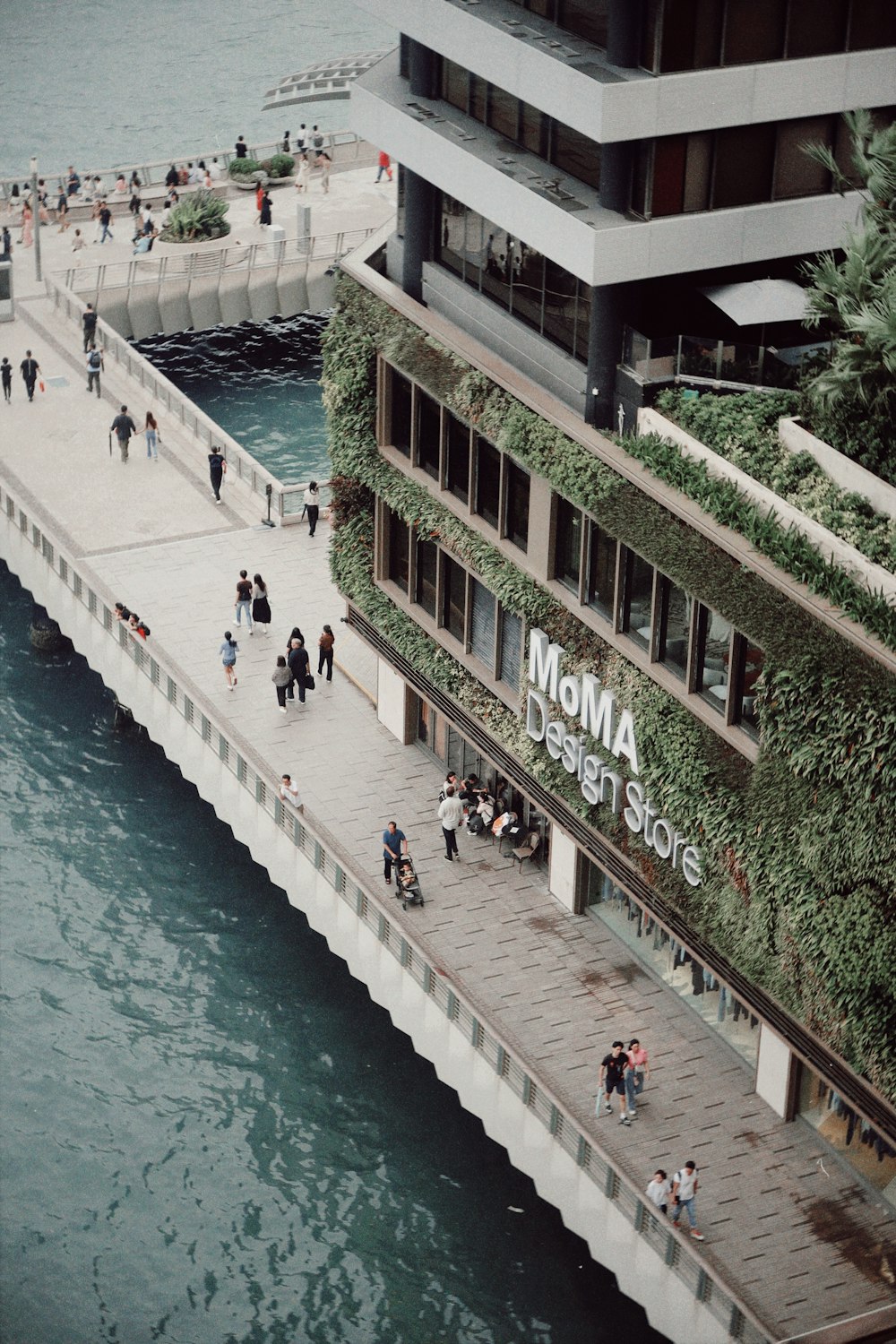 a group of people walking across a bridge next to a body of water