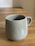 Close-up of a handmade terracotta mug with soft natural light highlighting its texture.