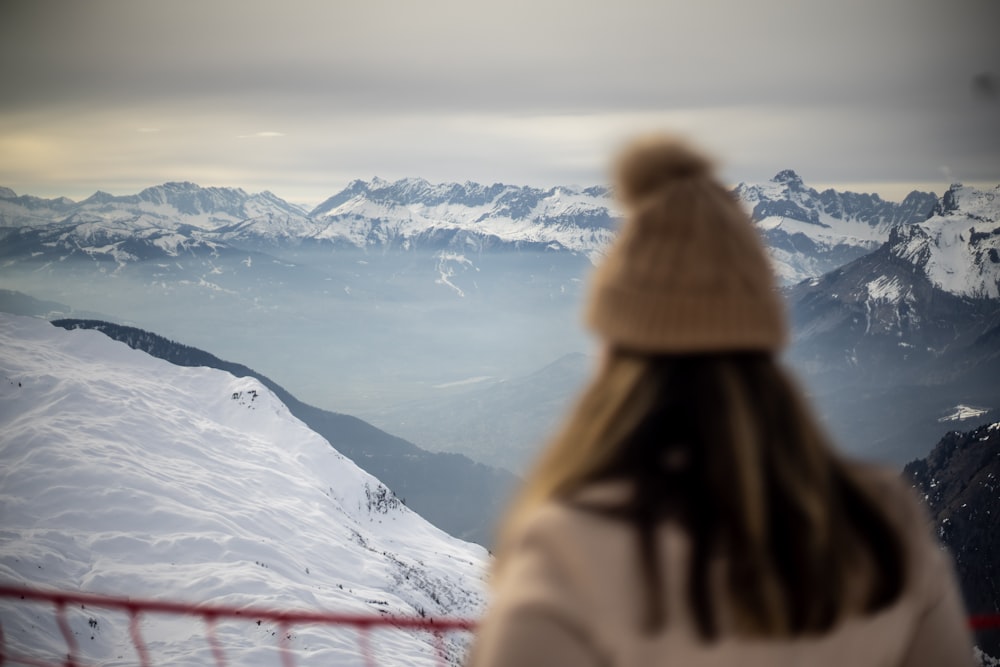 a woman standing on top of a snow covered mountain