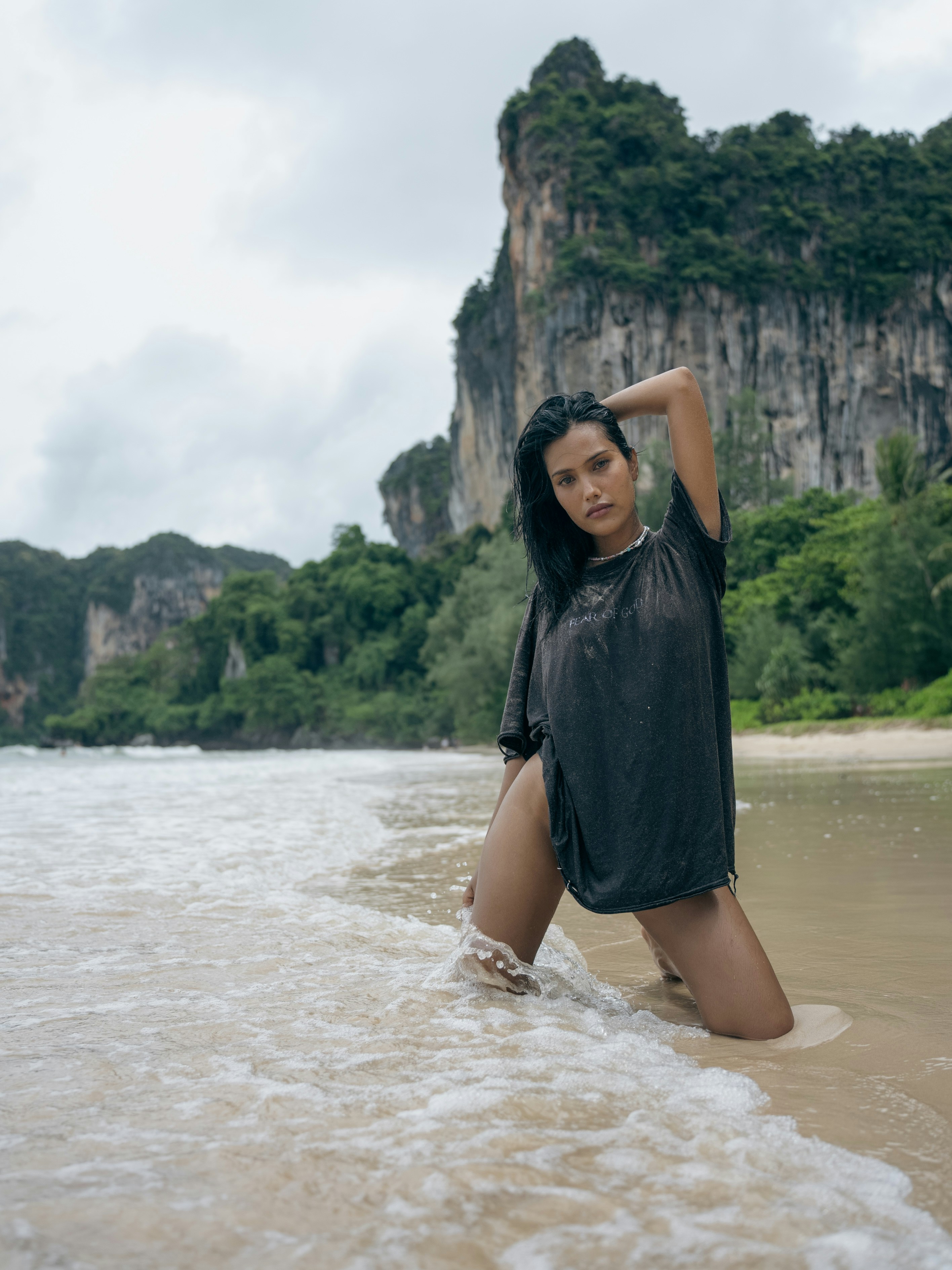 Une femme se tient dans l’eau à la plage