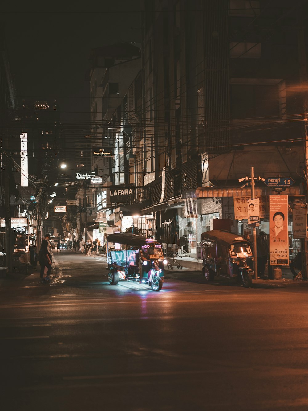 a busy city street at night with people and vehicles