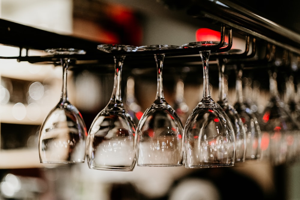 a row of wine glasses hanging from a rack