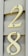 Cream-colored numbers, 2 and 8, are mounted with screws on a beige, wood-textured background, likely representing house siding.