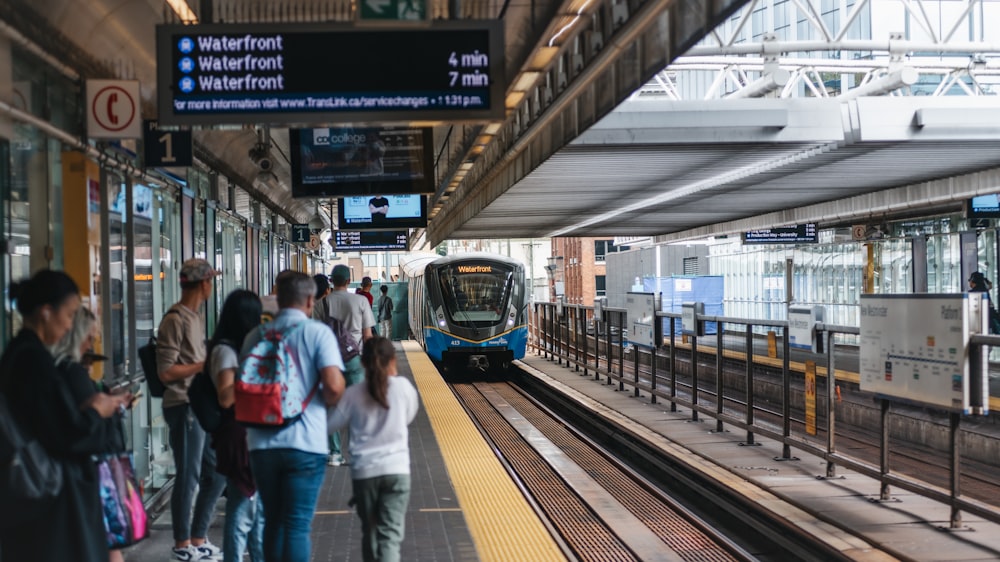 a group of people waiting for a train at a train station