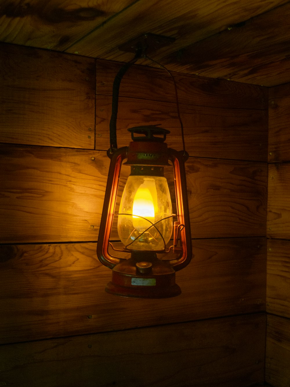 a light hanging from the side of a wooden wall