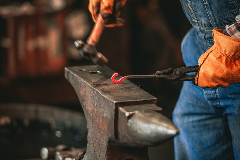 a man holding a hammer and a pair of gloves