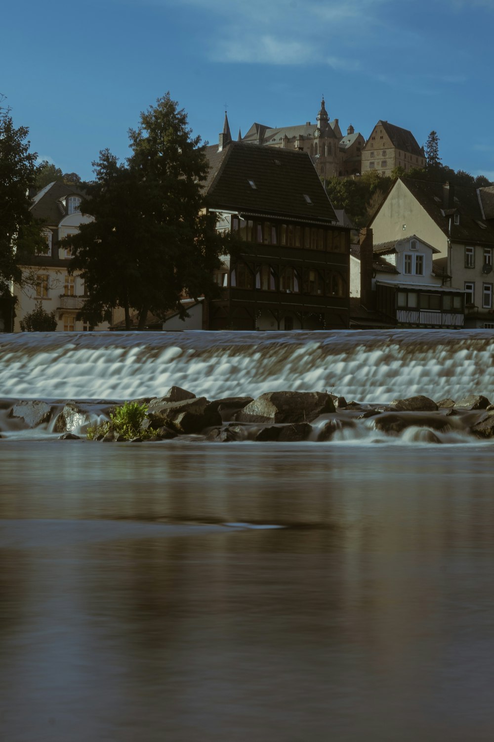 a river running through a small town next to tall buildings