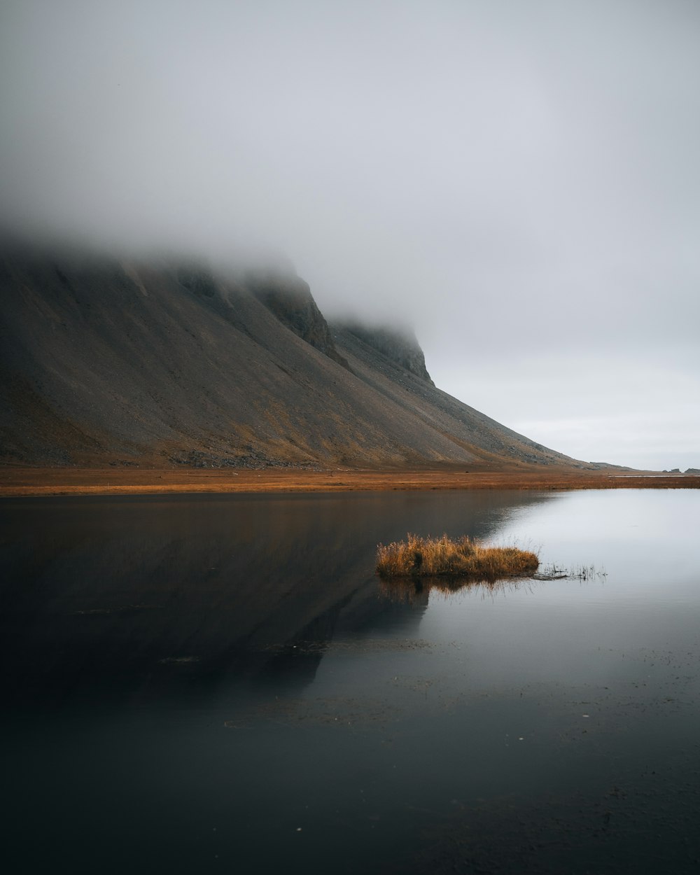 a body of water with a mountain in the background