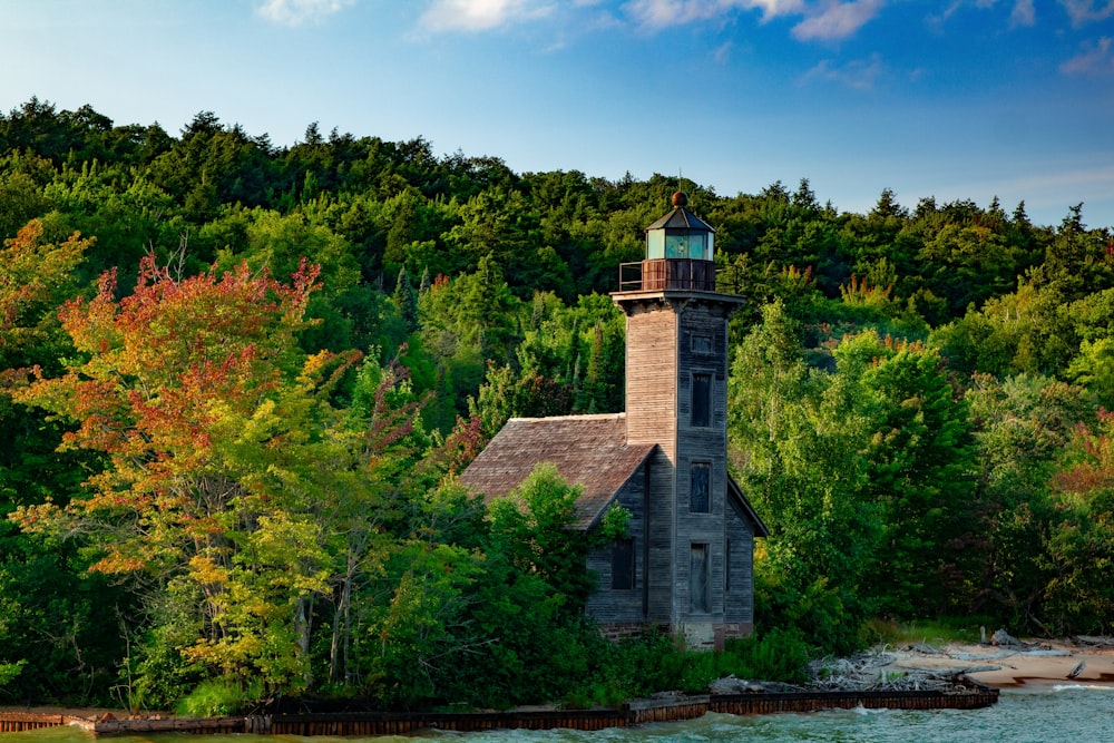 a lighthouse on a small island surrounded by trees