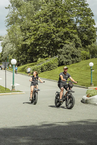A group of friends enjoying a ride through a leafy park on e-bikes.