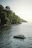 A smiling couple enjoying a boat ride through lush mangroves with clear blue skies overhead.