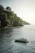 A smiling couple enjoying a boat ride through lush mangroves with clear blue skies overhead.