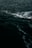 Dark ocean water with visible waves and white foam on the surface.