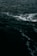 Dark ocean water with visible waves and white foam on the surface.