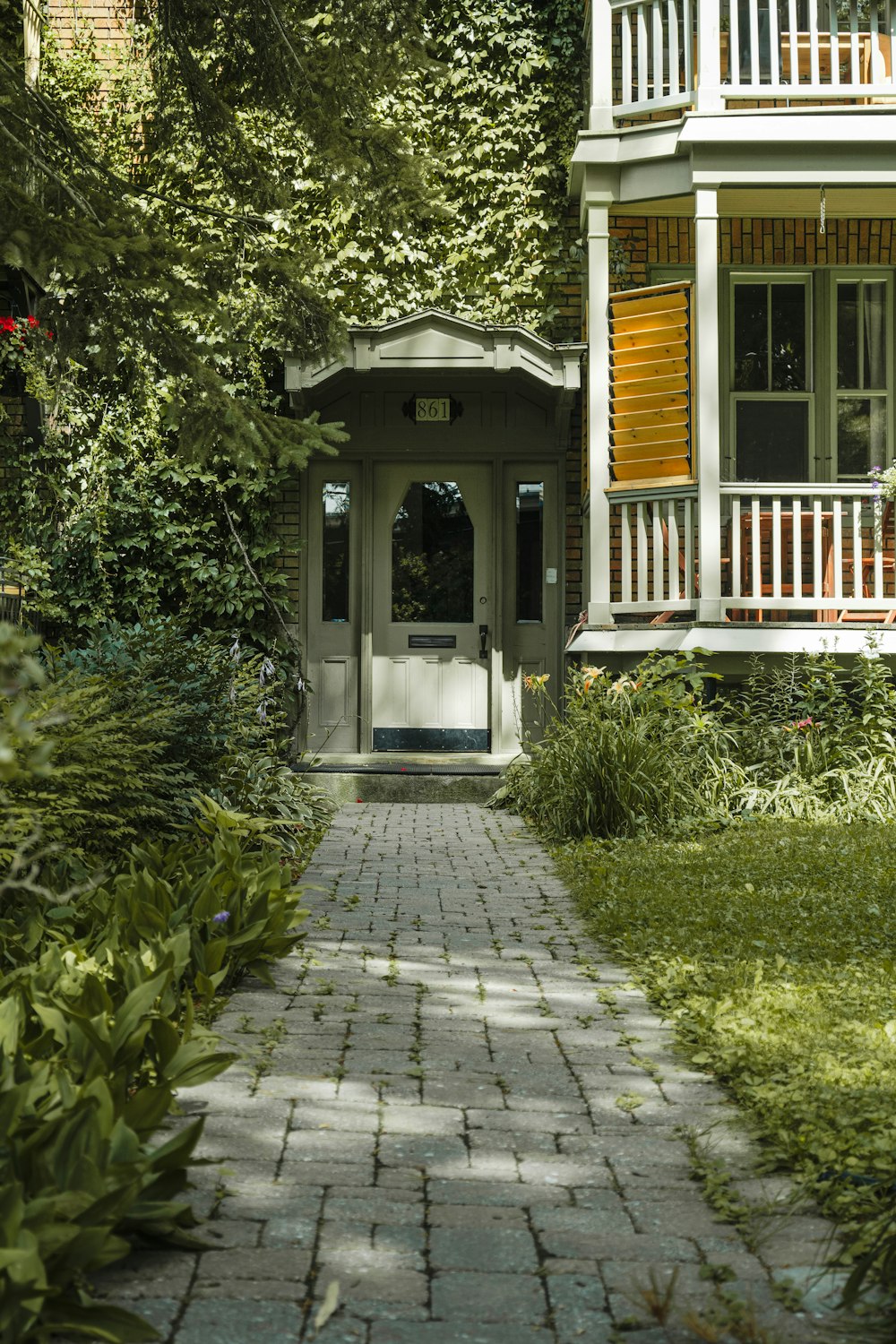 a small white house with a porch and a covered walkway