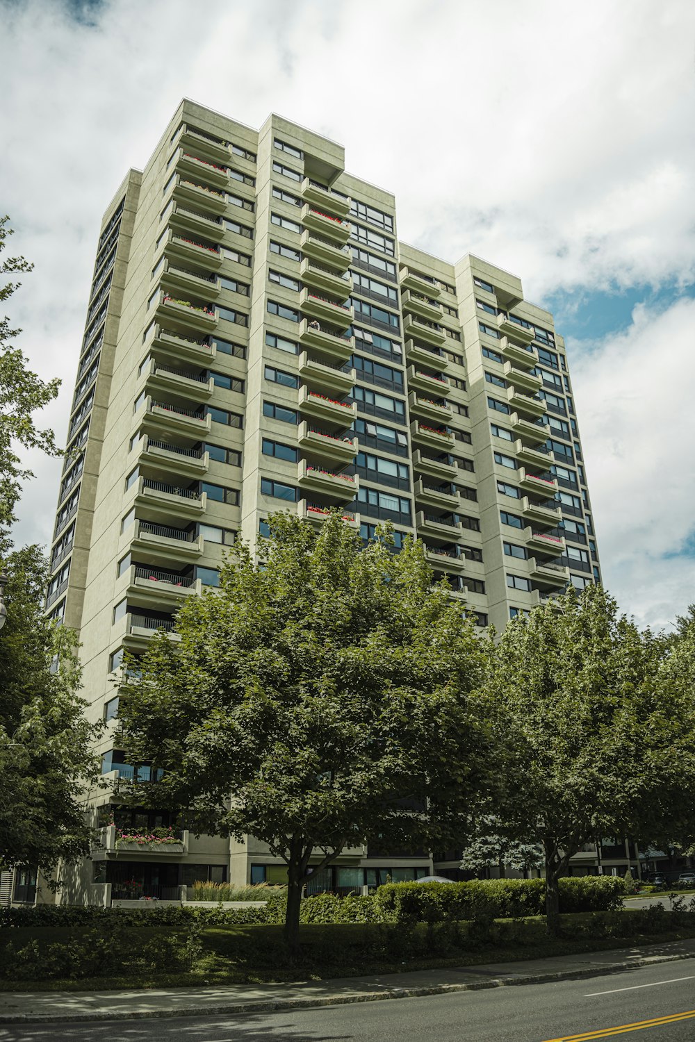 a tall building sitting next to a lush green forest