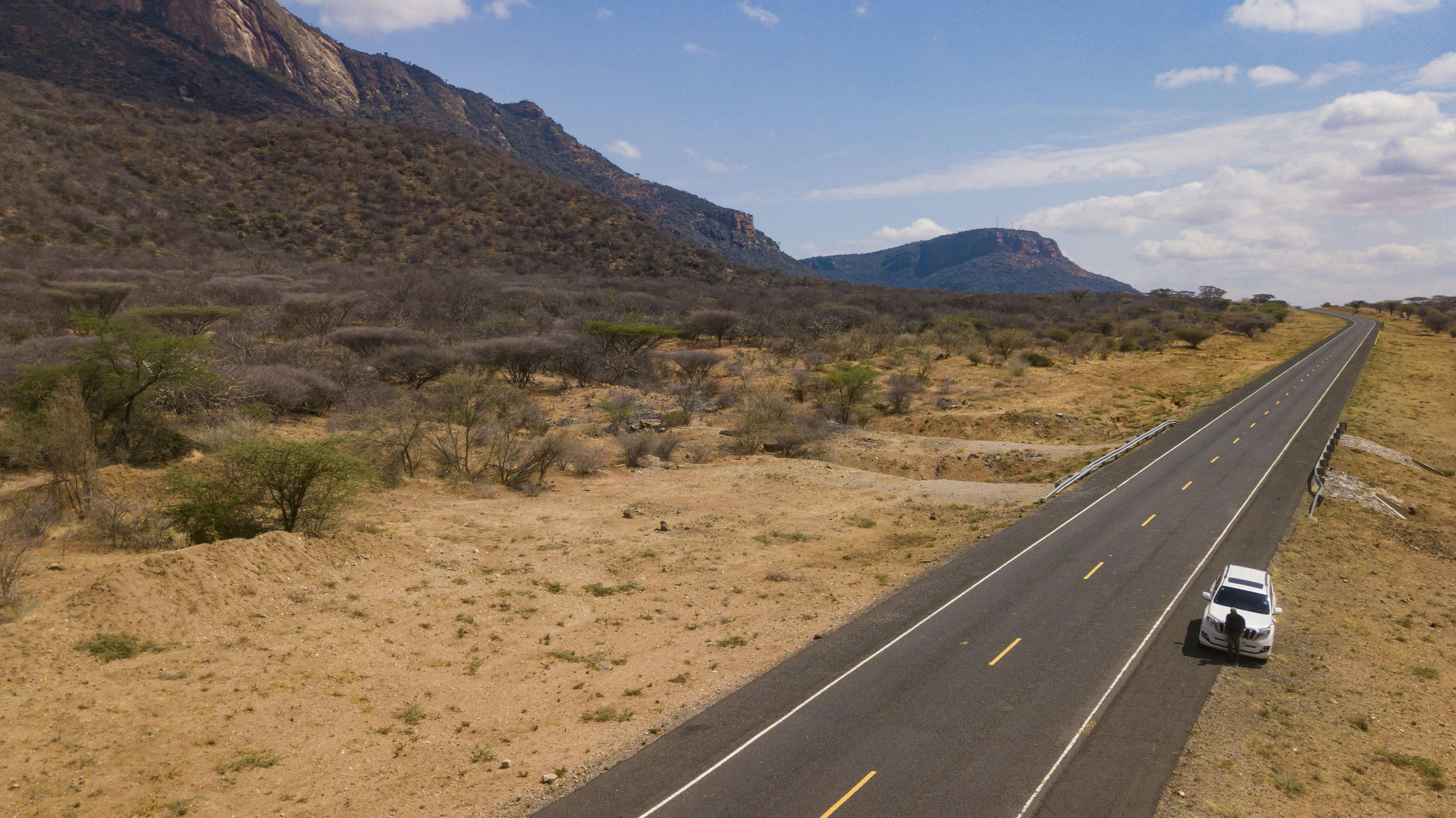 a car driving down a road in the middle of the desert